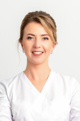 Close-up portrait of young smiling female caucasian healthcare worker standing staring at the...