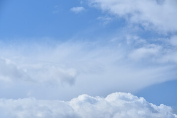 Białe spiętrzone chmury na błękitnym niebie - obrazy, fototapety, plakaty