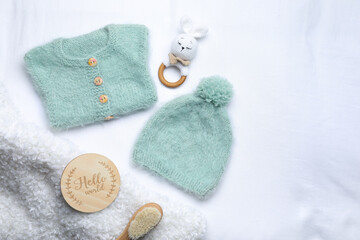 Flat lay composition with child's clothes and accessories on white fabric, space for text