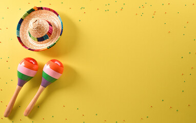 Cinco de Mayo holiday background made from maracas and hat on yellow background.