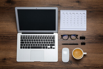 Modern laptop, cup of coffee and office stationery on wooden table, flat lay. Distance learning