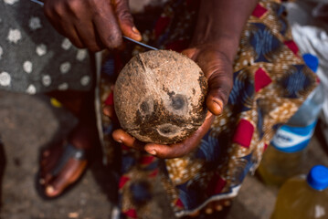 A woman cracks open a coconut fruit with a knife during the holy month of Ramadan Lagos Island, Lagos NIGERIA, April 8 2022.