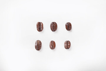 Roasted coffee beans, top view of six roasted beautiful coffee beans on isolated white background. 