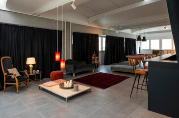 Detail of the room with a pool table, a sitting area with armchairs and sofas and a bar corner