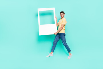 Full size portrait of active energetic person hold paper album moment card isolated on turquoise...