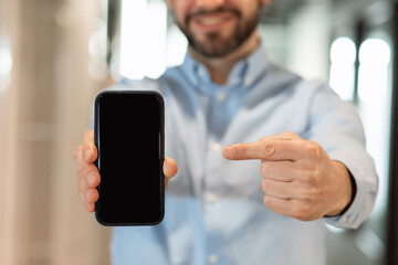 Businessman pointing at black empty smartphone screen