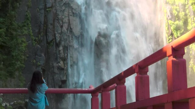 A woman looking at Nachi Falls.