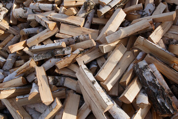 A pile of stacked firewood, prepared for heating the house. Firewood harvested for heating in winter.