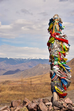 Buddhist sanctuary on a mountain pass in the Republic of Tuva in Russia with colorful ribbons on a pillar