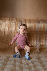 Naklejka premium Cute baby sitting in her outfit