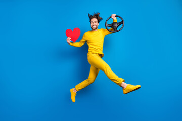 Full length body size view of handsome cheery trendy guy jumping driving red heart isolated over...