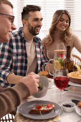 Group of people having brunch together at table indoors