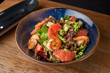 salad with avocado and shrimps in bowl, selective focus