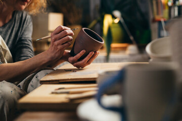 woman carving pottery in her workshop