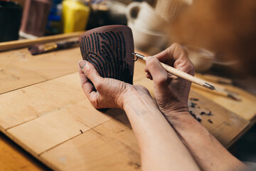 woman carving pottery in her workshop