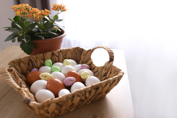 Fototapeta na wymiar chicken eggs lie with a straw basket on wooden background.. Top view. Free space. Easter eggs. High quality photo