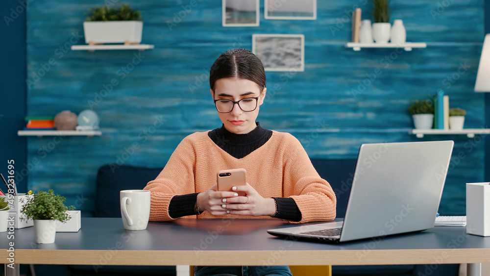 Aufkleber person sitting at desk and using smartphone to browse internet for online school research. woman pla