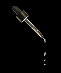 Drops drip down from a cosmetic pipette on a black background