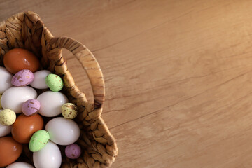chicken eggs lie with a straw basket on wooden background.. Top view. Free space. Easter eggs. High quality photo