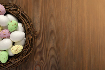 Colored chicken and quail eggs in a nest on a wooden background. Top view. Free space. Easter eggs. High quality photo