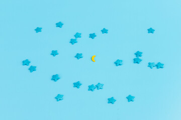 Sugar sprinkles in shape of star moon sticks on light blue background. Spase for text. Easter concept.