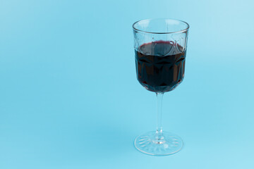 Port wine or fortified red wine  in a glass on blue background. copyspace.