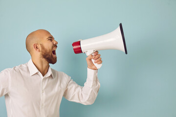 Young man isolated on green studio background scream in loudspeaker make sale announcement to public. Male hold megaphone shout advertise inform big sale deal or promotion discount. Advertisement. - obrazy, fototapety, plakaty