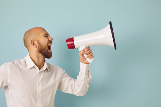 Young man isolated on green studio background scream in loudspeaker make sale announcement to public. Male hold megaphone shout advertise inform big sale deal or promotion discount. Advertisement.