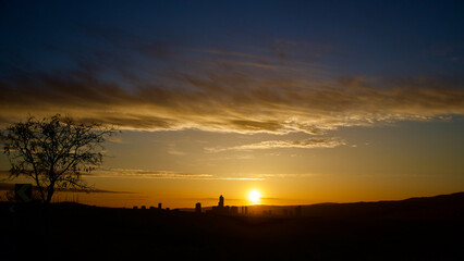 Fototapeta premium Colorful sky and distant city panorama at sunrise.