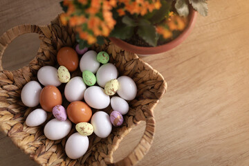 chicken eggs lie with a straw basket on wooden background.. Top view. Free space. Easter eggs. High quality photo
