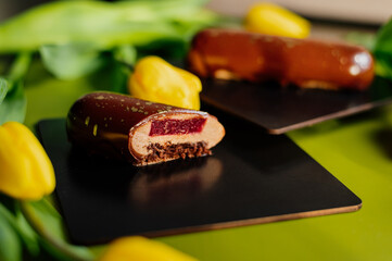 Beautiful mousse cakes covered with mirror shiny glaze. Green back ground. The skill of the pastry chef.