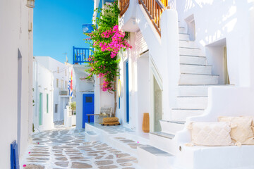 The island of Mykonos, Greece. Streets and traditional architecture. White-colored buildings and bright flowers. Travel photography. - obrazy, fototapety, plakaty