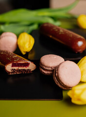 Yellow tulips next to macarons. Tulips on a green background. Spring mood. Tulips from Holland. 