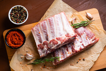 Raw ribs with rosemary on a wooden board