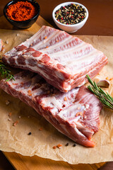 Raw ribs with rosemary on a wooden board