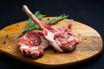 raw tomahawk with rosemary on a wooden board