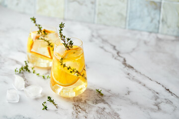Refreshing cocktail with ice, orange and thyme. Refreshing summer homemade alcoholic or...