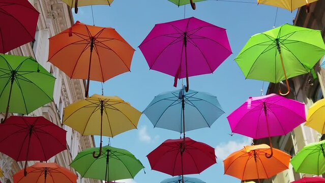 multicolored umbrella hanging on the street on a sunny day