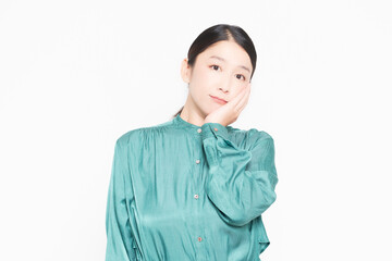 白背景の前で、頬に手を当てている主婦