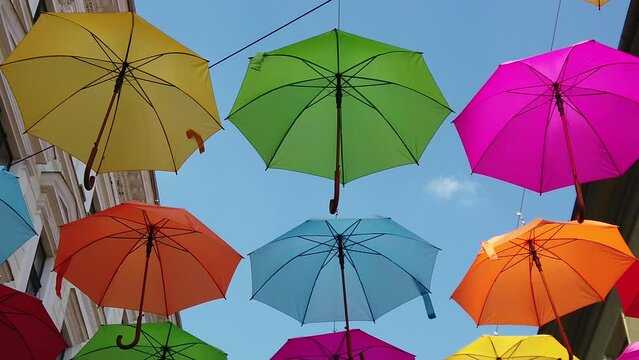 multicolored umbrella hanging on the street on a sunny day