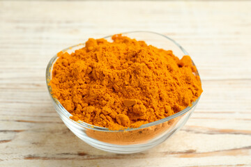 Aromatic saffron powder in bowl on white wooden table