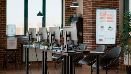 Empty workstation with customer service technology on desk, offering telemarketing assistance to people. Telecommunication office with headphones and computers at call center.