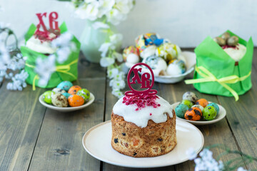 Happy easter concept. Easter wooden table with Easter cakes and colored eggs. topper with Russian...