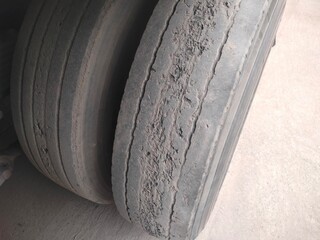 Old truck tire is damaged. Damaged and worn black rubber tubes are dangerous in use. Selective focus