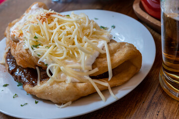 Lángos over the plate in restaurant of Budapest, traditional Hungarian food 