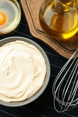 Bowl with fresh mayonnaise and ingredients on napkin, flat lay