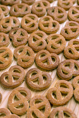Pretzels sprinkled with sugar lie on a wooden surface