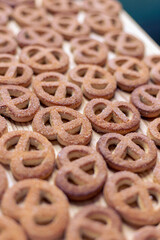 Pretzels sprinkled with sugar lie on a wooden surface
