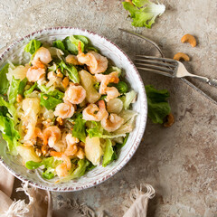 bowl with salad with pomelo and shrimps on the table