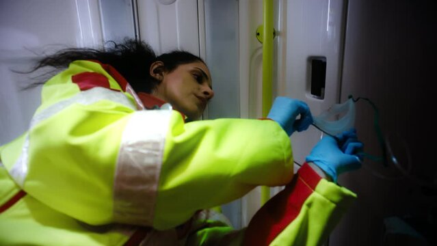 Pov of a Patient Laying on a Stretcher At the Back of an Ambulance Car As The Young Ethnic Medical Person Takes Out an Oxygen Mask to Put It On The Patient.